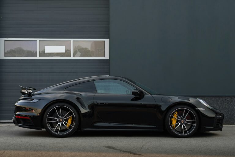 Front view of the 2026 Porsche 911 Carrera in motion on a mountain road